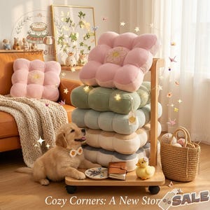 May include: A stack of colorful, square floor cushions in pink, green, and blue hues, with a flower design. A golden retriever puppy with a bow tie sits near the cushions. The text "Cozy Corners: A New Story" is at the bottom.