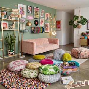以下が含まれることがあります： ピンクのベルベットのソファ、カラフルな丸いフロアクッション、柄のラグがあるリビングルーム。壁にはアートプリントと「CHIC」のネオンサインが飾られています。ゴールドの棚とハンギングプラントがインテリアを完成させています。