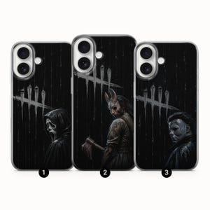 Può includere: Tre custodie per telefono nere con disegni a tema horror. Le custodie presentano immagini di personaggi del genere horror, tra cui una figura con una maschera di Scream, un personaggio con una maschera da coniglio e un uomo con i capelli scuri. Ogni custodia ha uno sfondo scuro.