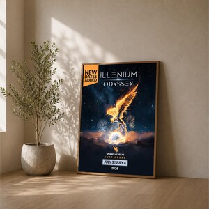 May include: A framed poster for the Illenium Odyssey event in Las Vegas, with the dates July 3 & 4, 2026. The artwork features a fiery phoenix against a starry background. The poster is displayed on a wooden surface.