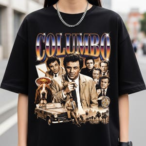 May include: Black t-shirt featuring a graphic design with the word "COLUMBO" in a retro font. The design includes images of the TV show's characters, a dog, a car, and palm trees. The design has a vintage, distressed look.