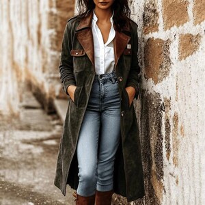 Peut inclure: Un long manteau en daim vert olive avec des revers en cuir marron, deux poches poitrine à rabat et des boutons. Le manteau est porté sur une chemise blanche boutonnée et un jean bleu clair à taille haute avec des coutures apparentes.
