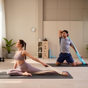 May include: Two people are shown stretching with resistance bands on yoga mats. One person is kneeling and the other is seated. The room has a neutral color palette with plants and a clock on the wall. The resistance bands are light blue and beige.