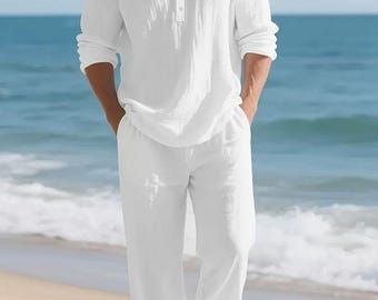 Può includere: Un completo in lino bianco composto da una camicia con colletto alla coreana e abbottonatura, abbinato a pantaloni in lino bianco coordinati. L'outfit è indossato con sandali marroni su una spiaggia sabbiosa con l'oceano sullo sfondo. Il testo "FASHION FORWARD" è visibile.