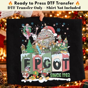 May include: A black DTF transfer featuring a festive Disney-themed graphic with Epcot, Mickey Mouse, Minnie Mouse, Donald Duck, Daisy Duck, Goofy, and Pluto in holiday attire. The design includes the text EPCOT SINCE 1982 with snow accents.