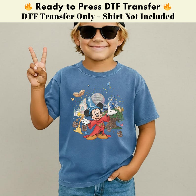 Pode incluir: Camiseta azul com um desenho do Mickey Mouse vestido de mago, com um castelo e elementos m&aacute;gicos. O texto na parte superior diz "Ready to Press DTF Transfer" e "DTF Transfer Only - Shirt Not Included".