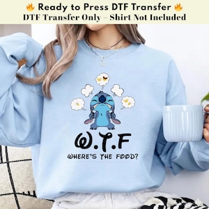 Könnte beinhalten: Hellblaues Sweatshirt mit einem Stitch-Motiv und dem Text "W.T.F. WHERE'S THE FOOD?". Das Design zeigt Stitch mit Gedankenblasen. Der obere Text lautet "Ready to Press DTF Transfer" und "DTF Transfer Only - Shirt Not Included".