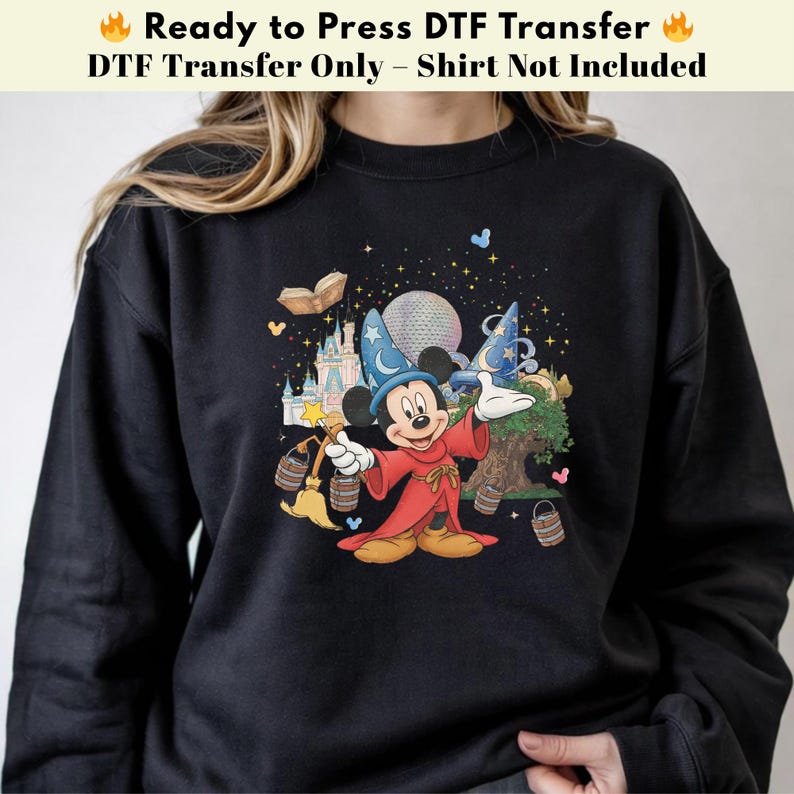 Pode incluir: Camisola preta com um gr&aacute;fico colorido do Mickey Mouse com uma roupa de feiticeiro, com um castelo, um globo e estrelas. O texto na parte superior diz "Ready to Press DTF Transfer".