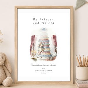 May include: A framed wall art print titled The Princess and the Pea, featuring a watercolor illustration of a person climbing a tall stack of colorful mattresses. The text reads, Kindness is a language that everyone understands, by Hans Christian Andersen.