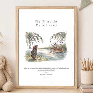 Op de afbeelding: Een ingelijste kunstdruk met een aquarelillustratie van een mol op een rivieroever en een rat in een roeiboot. De tekst luidt The Wind In The Willows en bevat een citaat van Kenneth Grahame over het varen met een boot.