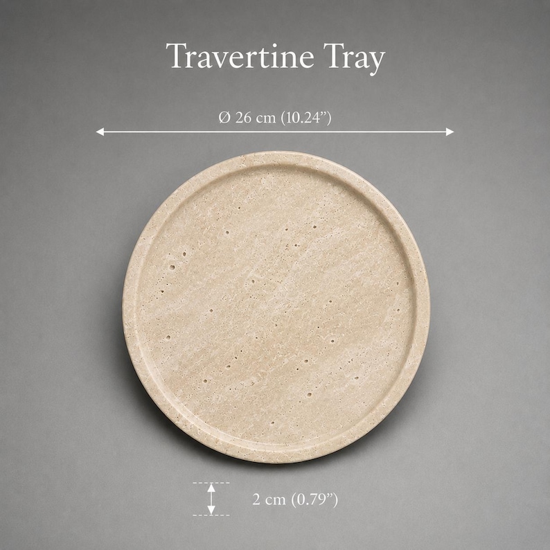 Puede incluir: Una bandeja redonda de travertino beige con una superficie porosa y texturizada. El texto Travertine Tray es visible sobre el objeto. Una l&iacute;nea de dimensi&oacute;n indica un di&aacute;metro de 26 cm y una altura de 2 cm, o 10,24 y 0,79 pulgadas.