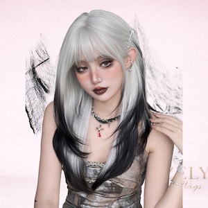 Puede incluir: Una peluca larga y en capas con un diseño de dos tonos. La parte superior es de color gris plateado claro, que pasa a negro en la parte inferior. La peluca tiene flequillo y está peinada con una pinza para el pelo. La persona lleva un collar de gargantilla con un colgante de cruz.