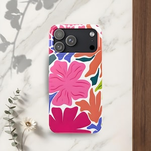 May include: A phone case with a vibrant floral design. The case features a white background with large pink, orange, and blue flower and leaf shapes. The phone's camera lenses are visible at the top.
