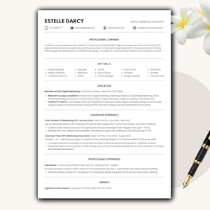 May include: A professional resume template with the name "Estelle Darcy" at the top. The resume includes sections for professional summary, key skills, education, leadership experience, professional experience, and awards. A black and gold pen and white flowers are in the background.