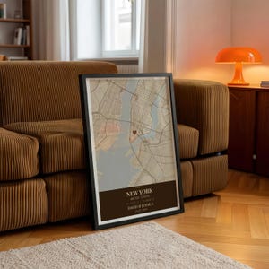 May include: Framed map print of New York City, featuring a heart marking a specific location. The map has a vintage aesthetic with a brown and beige color scheme. The bottom of the frame includes the text "NEW YORK", coordinates, and names "DAVID & JESSICA" with a date.