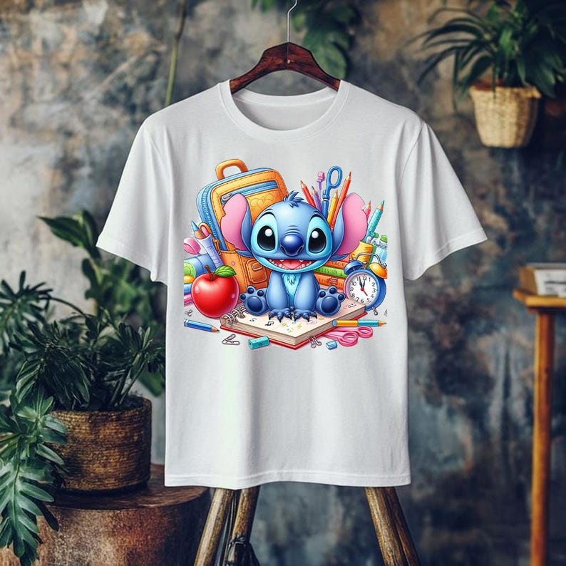 May include: White t-shirt featuring a cartoon illustration of Stitch from Lilo & Stitch. Stitch is surrounded by school supplies, including a backpack, pencils, an apple, and a clock. The design is colorful and vibrant, perfect for fans of the animated film.