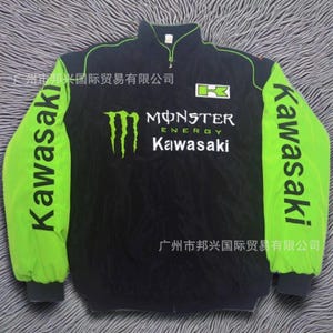 Peut inclure: Veste zippée noire et verte avec le logo "Monster Energy Kawasaki". Les manches sont vert vif avec "Kawasaki" imprimé verticalement. Col montant et petite fermeture éclair.
