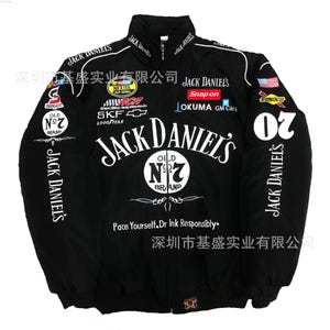 Puede incluir: Chaqueta de carreras negra con detalles blancos y varios logotipos de patrocinadores. El logotipo de "Jack Daniel's" se muestra de forma destacada en la parte delantera y trasera. El número "20" está en la manga derecha. Con el texto "Pace Yourself. Dr Ink Responsibly."