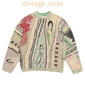 May include: A long-sleeve knit sweater featuring the text "Vintage Jackt" at the top. The garment displays a complex, multi-colored pattern including shades of cream, light green, lavender, and red, with abstract human figures and geometric shapes.