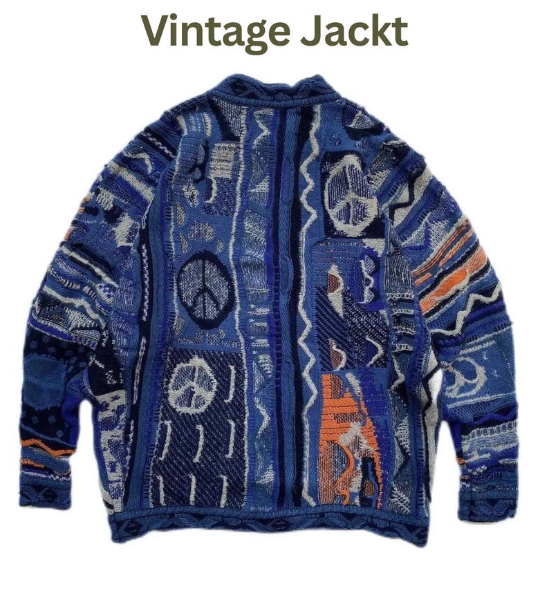 May include: A long-sleeve knit sweater featuring a complex patchwork of blue, navy, and orange geometric patterns, including multiple peace sign motifs. The text "Vintage Jackt" is printed in dark green above the garment on a white background.