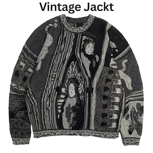 May include: A long-sleeve knit sweater in shades of black, gray, and white featuring the text "Vintage Jackt" at the top. The garment displays a complex, multi-panel jacquard pattern with abstract shapes, textured vertical stripes, and human figures.