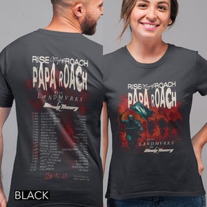Könnte beinhalten: Ein anthrazitfarbenes Kurzarm-T-Shirt mit einem Papa-Roach-Konzertmotiv. Die Vorderseite zeigt einen Soldaten mit einer Flagge und roten Raucheffekten, während die Rückseite die Tourdaten und Orte für Rise of the Roach mit Landmvrks auflistet.