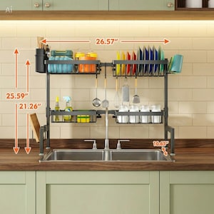 May include: A black, over-the-sink dish drying rack. It is 26.57 inches wide, 25.59 inches tall, and 10.63 inches deep. The rack has compartments for dishes, utensils, and cleaning supplies. It includes a utensil holder, plate rack, and space for bottles and jars.