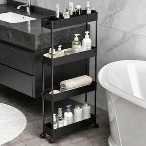 May include: A black, four-tier rolling storage cart filled with bathroom essentials. The cart features open shelves and is stocked with bottles, tubes, and a folded towel. It stands beside a white bathtub and a dark grey vanity unit, ideal for bathroom storage.