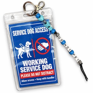 以下が含まれることがあります： 透明なプラスチック製のIDバッジホルダー。青いカードには白い文字でSERVICE DOG ACCESS、WORKING SERVICE DOG、PLEASE DO NOT DISTRACT、Allow accessと書かれています。青と白のビーズが付いたストラップにはDO NOT PETと綴られています。