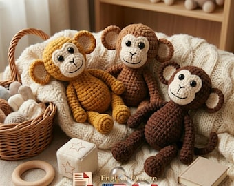May include: Three crocheted monkey plush toys in shades of brown and yellow are arranged on a cream-colored knitted blanket. The monkeys have white faces and smiling expressions. A wooden basket and other toys are in the background.