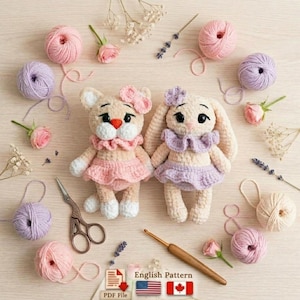 Puede incluir: Dos muñecas de ganchillo hechas a mano, un gato y un conejo, se exhiben con ovillos de lana, flores y herramientas de ganchillo. La muñeca de gato viste un vestido y un lazo rosas, mientras que la muñeca de conejo viste un vestido y un lazo morados.