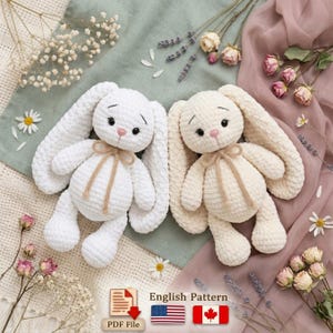 May include: Two handmade crochet bunny rabbits. One is white, the other is cream-colored. Both have long floppy ears, pink noses, and are tied with a tan ribbon. The image also includes a PDF file icon and text that says "English Pattern".
