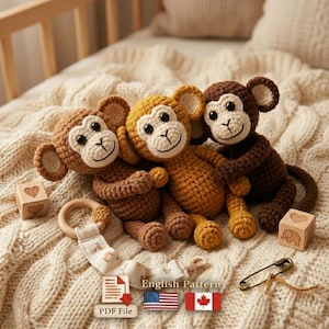 Puede incluir: Tres monos de peluche de ganchillo en tonos marrones y amarillos están colocados sobre una manta texturizada. Los monos tienen caras sonrientes y están rodeados de bloques de madera, un mordedor y un clip para chupete. El texto "English Pattern" es visible.
