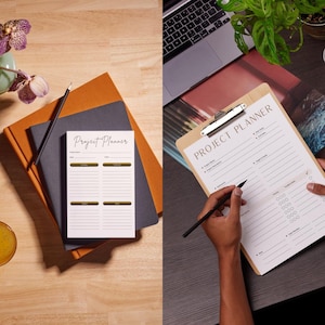 Può includere: Un blocco note per la pianificazione di progetti con un design oro e bianco, appoggiato sopra un taccuino grigio e arancione. Una matita è appoggiata sul blocco note. Una persona tiene in mano una lavagna con un modulo di pianificazione del progetto e una penna.
