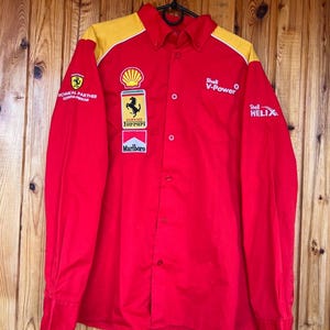 Könnte beinhalten: Eine weiße Keramiktasse mit schwarzem Henkel und dem Text "But first, coffee" in handschriftlichem Stil. Die Tasse steht auf einer weißen Oberfläche. Die Tasse ist 10 cm hoch.