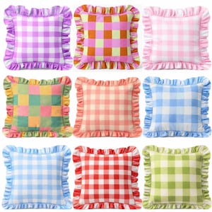 May include: Nine square throw pillows with ruffled edges. The pillows feature a gingham pattern in various colors, including purple, pink, orange, green, red, and blue. The ruffled edges provide a decorative touch to the pillows.