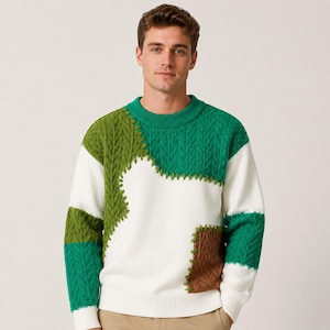 May include: A long-sleeve crew neck sweater featuring a color-blocked patchwork design. The knit garment combines sections of white, bright green, olive green, and brown, with visible decorative stitching connecting the various textured panels.