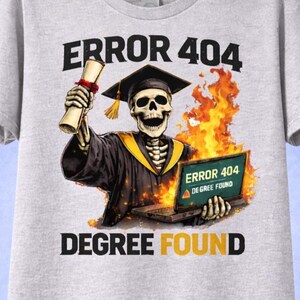 May include: A light grey t-shirt with a skeleton in a graduation cap and gown, holding a diploma and a laptop showing "ERROR 404 DEGREE FOUND" with flames. The text "ERROR 404" and "DEGREE FOUND" are printed above and below the graphic.