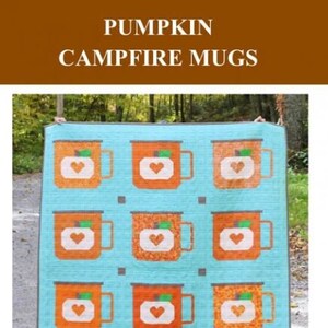 May include: A quilt featuring a pattern of orange mugs with pumpkin faces and white hearts on a light blue background. The quilt is titled "Pumpkin Campfire Mugs" and is by Satomi Quilts.