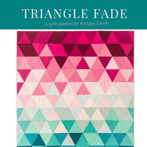 May include: Triangle Fade quilt pattern by Brittany Lloyd. The pattern features a gradient of pink, blue, and green triangles. The pattern is available in baby, small throw, and large throw sizes. The pattern is available from Lo & Behold Stitchery.