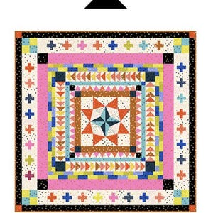 May include: A colorful quilt with a central starburst design, surrounded by geometric patterns in pink, blue, orange, and black. The quilt features the text "Marcelle Medallion Quilt" at the bottom and the brand name at the top.