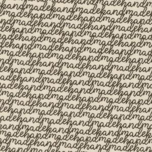 May include: A white fabric with a repeating pattern of the words "handmade" written in brown cursive.
