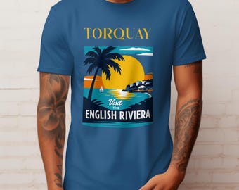May include: Blue t-shirt with a graphic of a tropical scene. The design features a yellow sun, palm tree, sailboat, and the text "TORQUAY" and "Visit the English Riviera". The shirt is a solid blue color.