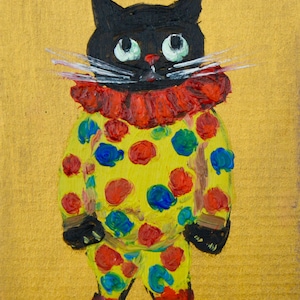 Könnte beinhalten: Ein skurriles Gemälde einer schwarzen Katze als Clown. Die Katze trägt ein gelbes Outfit mit roten und blauen Punkten, einen roten Rüschenkragen und rote Stiefel. Der Hintergrund ist goldfarben.