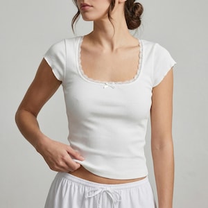 Spetskantad ribbad babytröja, åtsittande rund halsringning, mjuk stretchig kortärmad topp