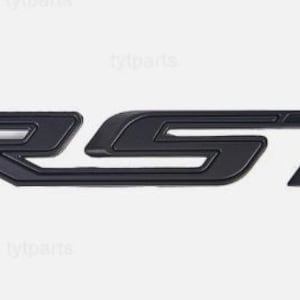 Puede incluir: Un emblema RST negro con acabado mate. El emblema presenta las letras "RST" en una fuente estilizada sin serifa. Las letras están conectadas y tienen una apariencia ligeramente elevada, creando un efecto tridimensional. El emblema está diseñado para uso automotriz.