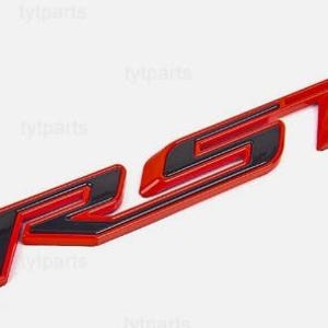 Puede incluir: Un emblema RS rojo y negro, probablemente para un vehículo. El emblema presenta un acabado brillante con las letras "RS" en una fuente estilizada. El fondo es blanco.