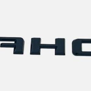 Puede incluir: Letras negras tridimensionales que deletrean la palabra "TAHOE". Las letras están espaciadas uniformemente y parecen estar hechas de un material brillante. El fondo es de un gris claro liso.