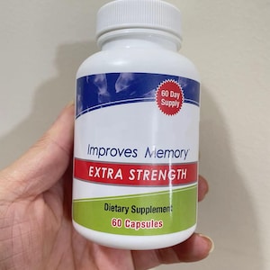 May include: A white plastic bottle with a white cap, labeled "Improves Memory EXTRA STRENGTH." The bottle also states "Dietary Supplement" and "60 Capsules." A red and white label indicates a "60 Day Supply."