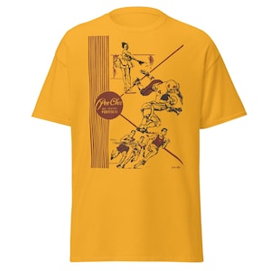 May include: Mustard yellow t-shirt featuring a vintage-style illustration. The graphic includes a football player, runners, and a dancer, with the text "Pee Chee All Stars Portfolio". The design is in shades of brown and red.